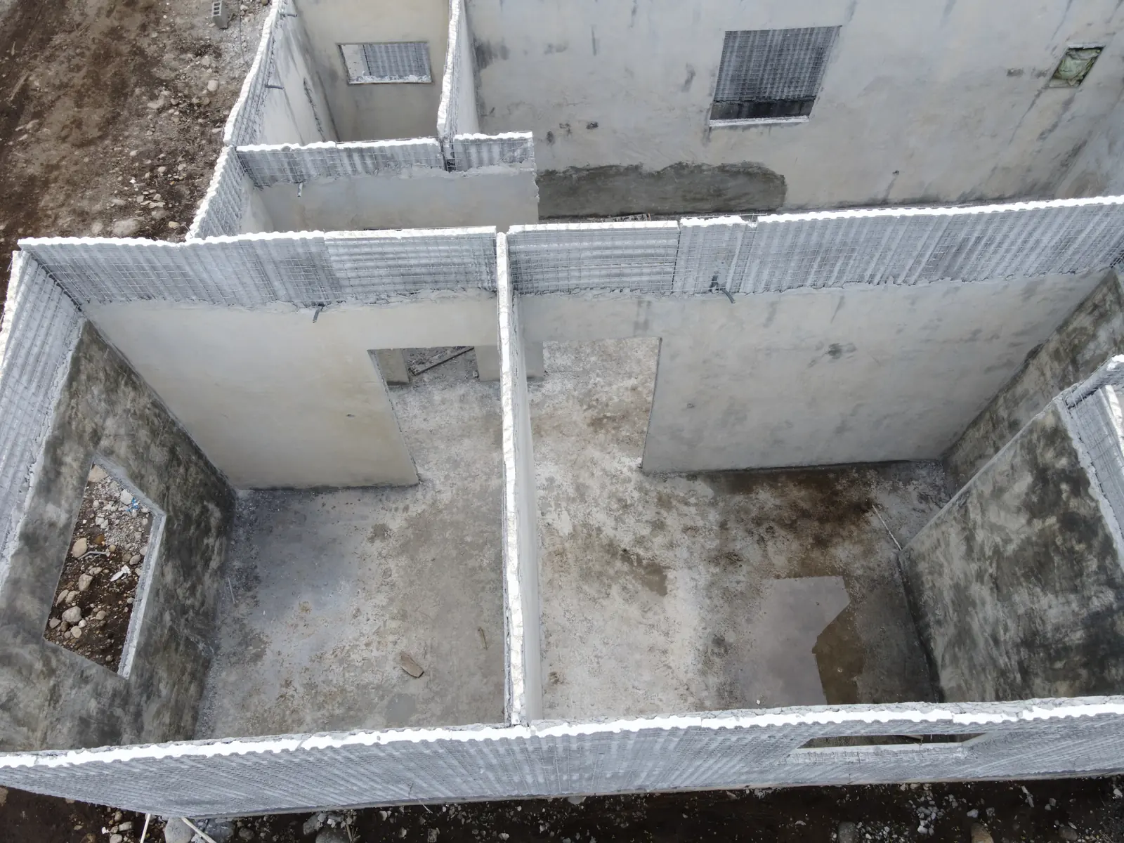 Detalle aéreo de vivienda con paneles y malla de acero expuesta